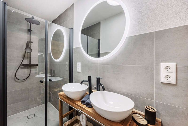 Badezimmer mit Dusche und Doppelwaschbecken