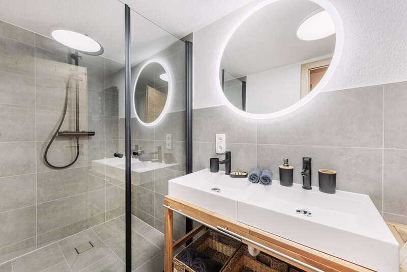 Badezimmer mit großer Dusche und Doppelwaschbecken
