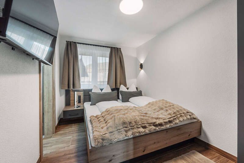 Doppelbettzimmer mit dem Bett an einer Wand 