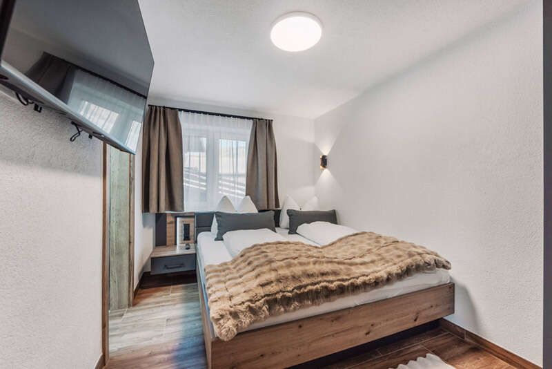 Schlafzimmer mit Doppelbett und TV