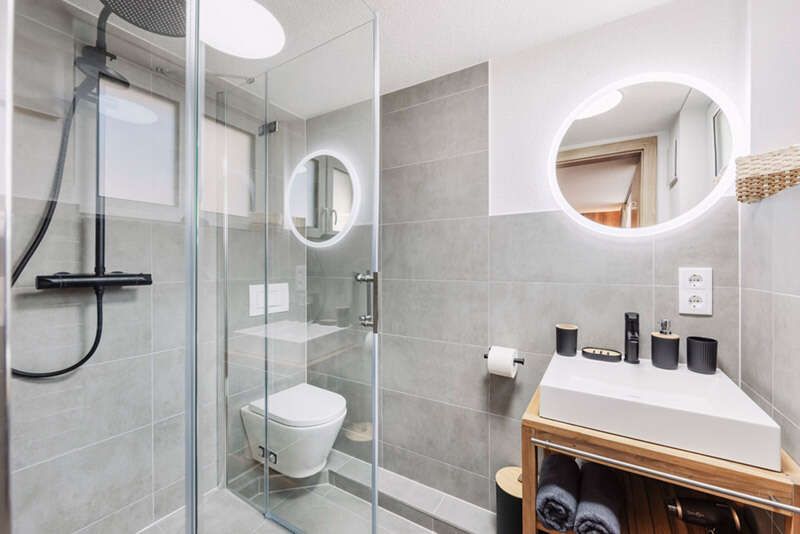 Badezimmer mit Dusche, Waschbecken und WC im Top 1